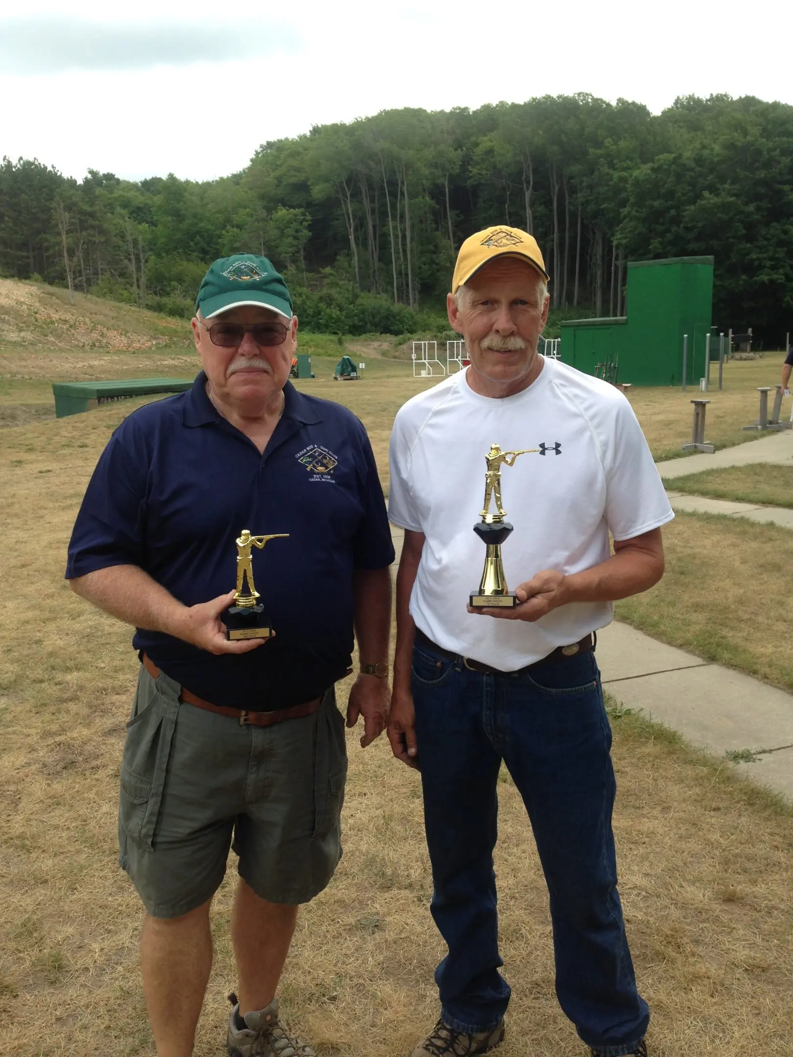 Two men holding trophies in their hands.